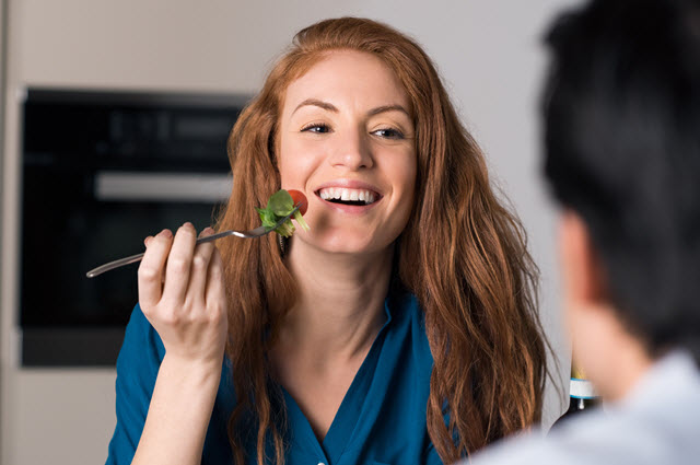 Une femme mange une tomate cerise
