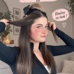 Femme avec une coiffure moderne et élégante réalisant un tutoriel de coiffure.